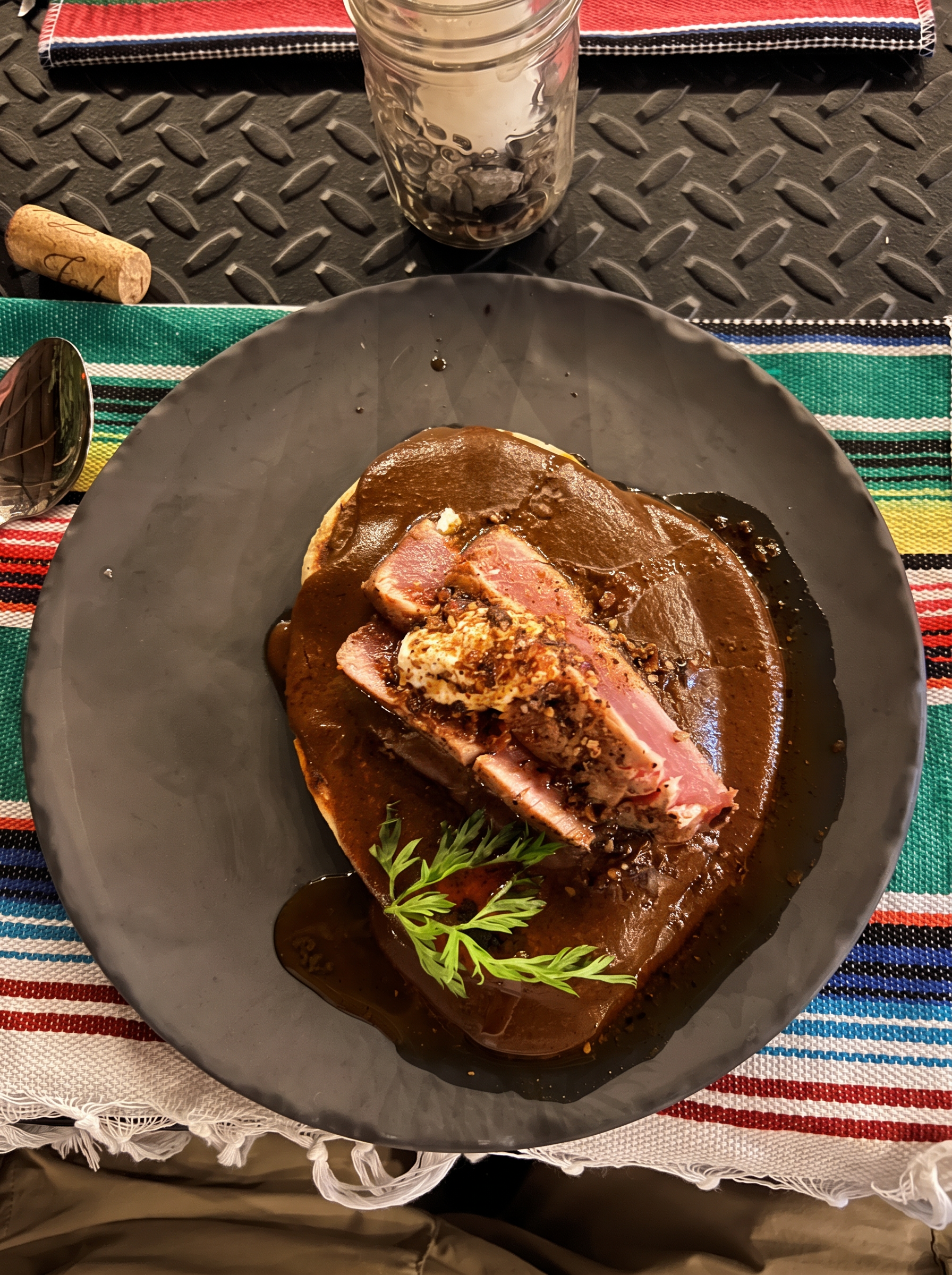 House mole plated with seared fish on a black clay plate