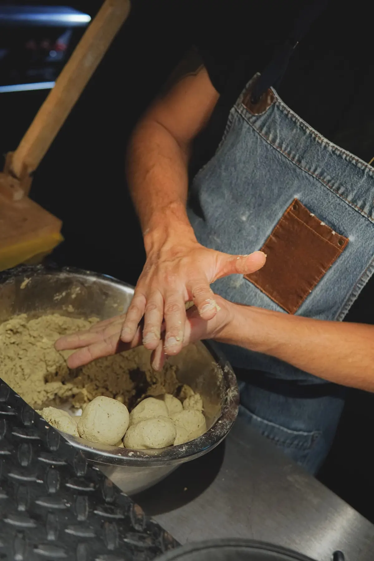 Hands kneading fresh masa from house-made nixtamal